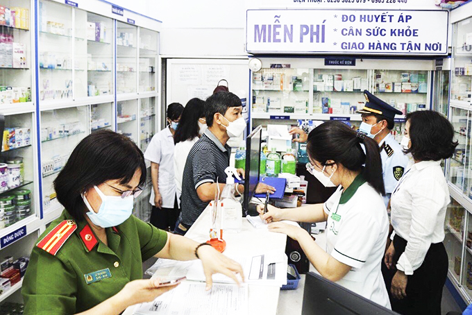 Lực lượng quản lý thị trường kiểm tra mặt hàng trang thiết bị y tế tại một hiệu thuốc ở TP. Nha Trang. Ảnh: Thái Thịnh